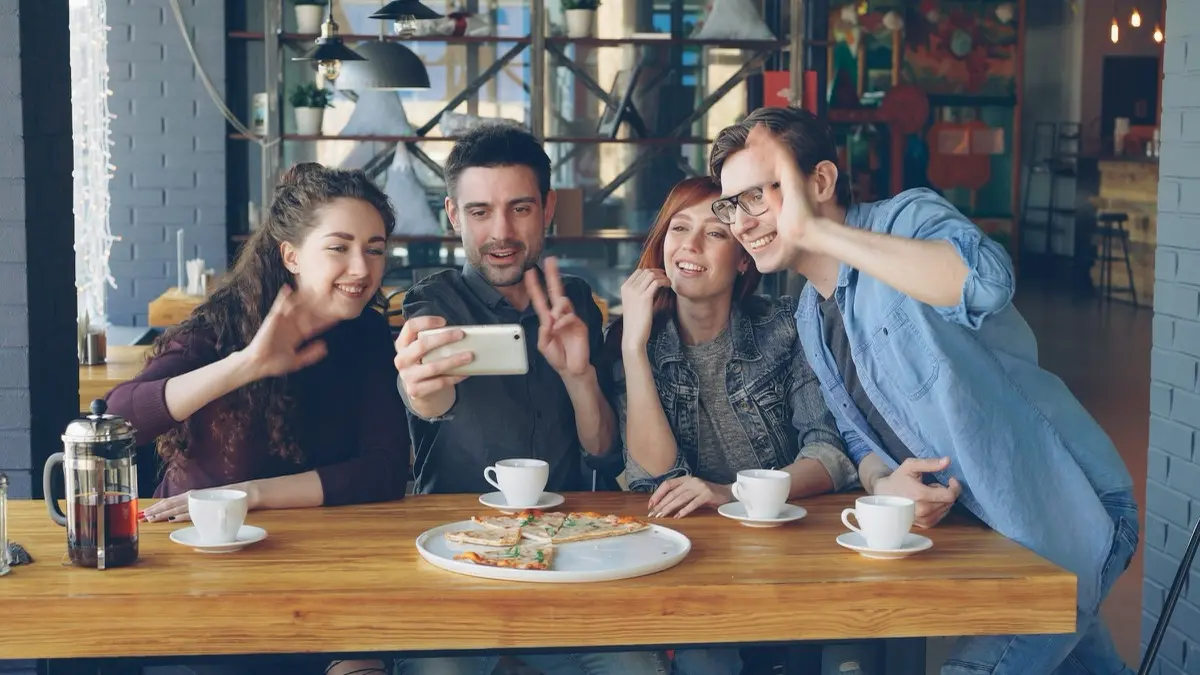 Friends video calling together at a cafe while traveling
