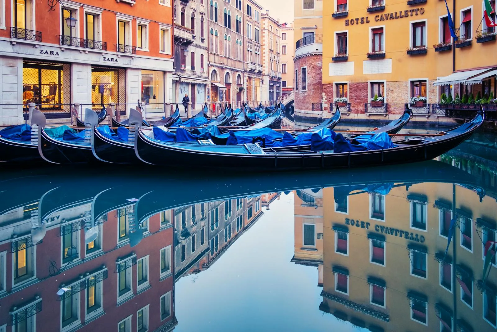 Gondolas and colorful buildings reflected on a Venice canal