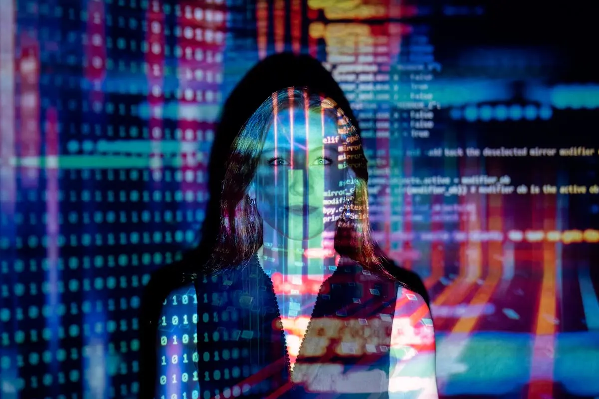 Woman using laptop and phone at a modern desk