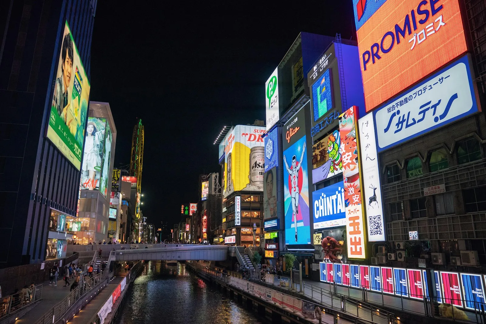 Dotonbori canal in Osaka at night with colorful neon billboards reflecting off the water