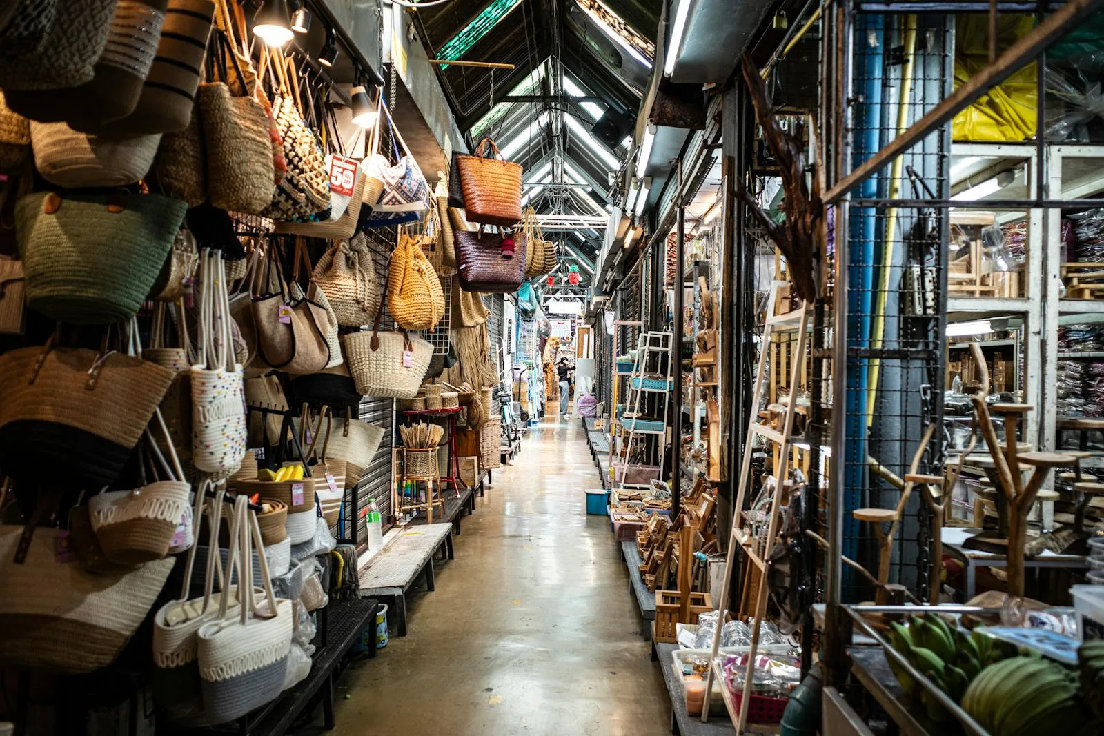 Busy indoor aisle at Chatuchak Weekend Market in Bangkok with clothing stalls and shoppers