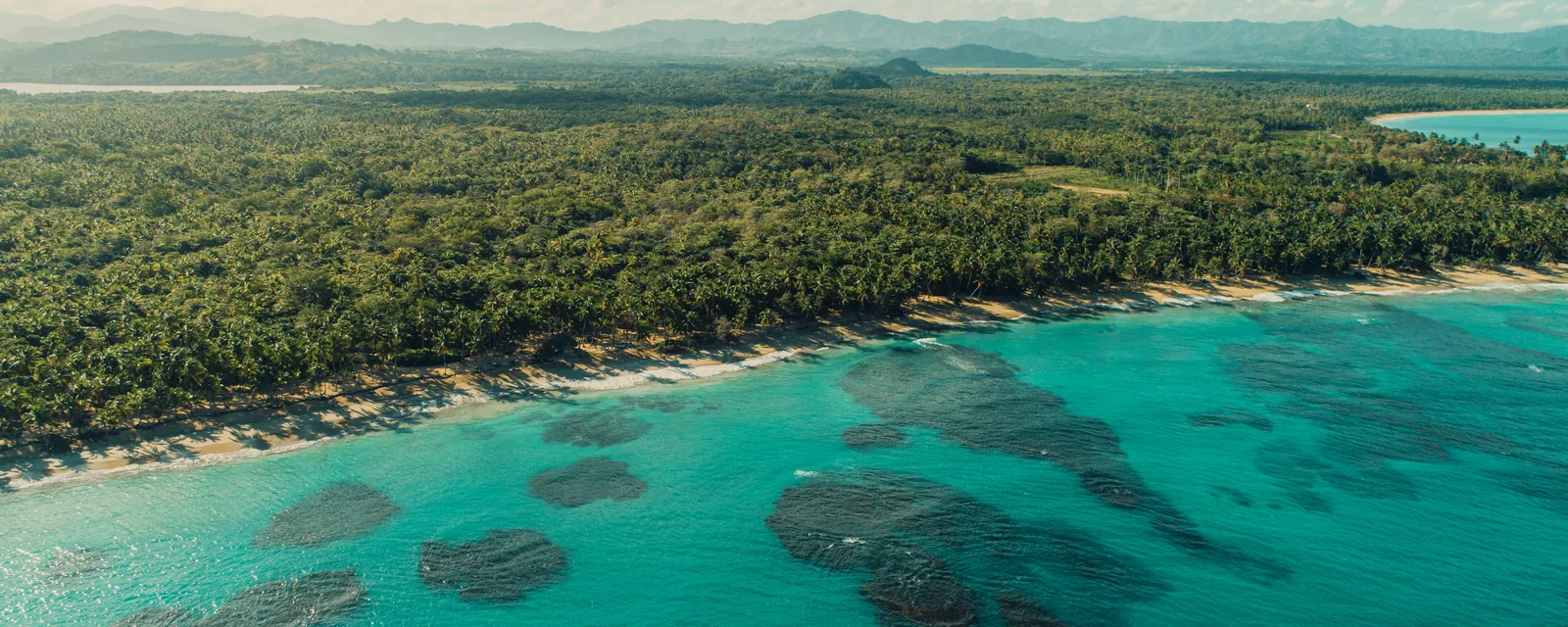 Green hills and turquoise coastal water near Miches, Dominican Republic