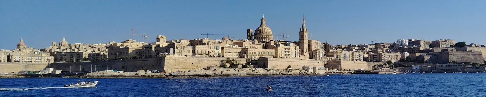 Valletta's domed skyline across blue Mediterranean water, Malta