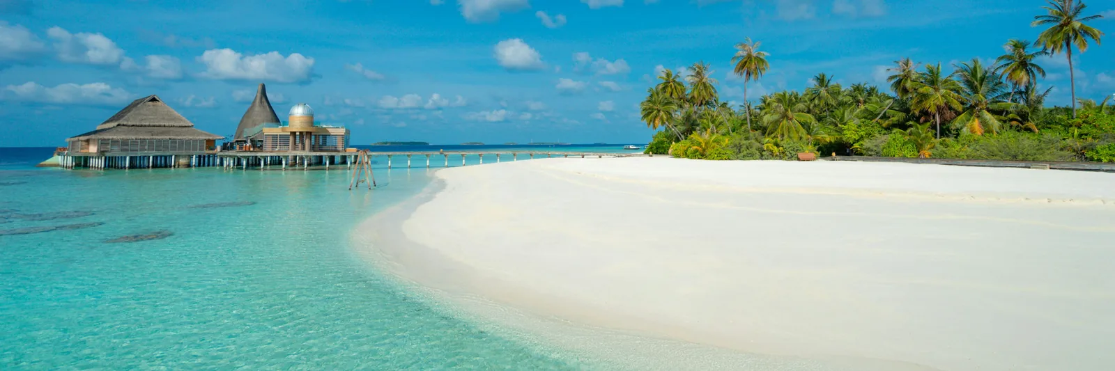 White sand beach and overwater pavilions in the Maldives