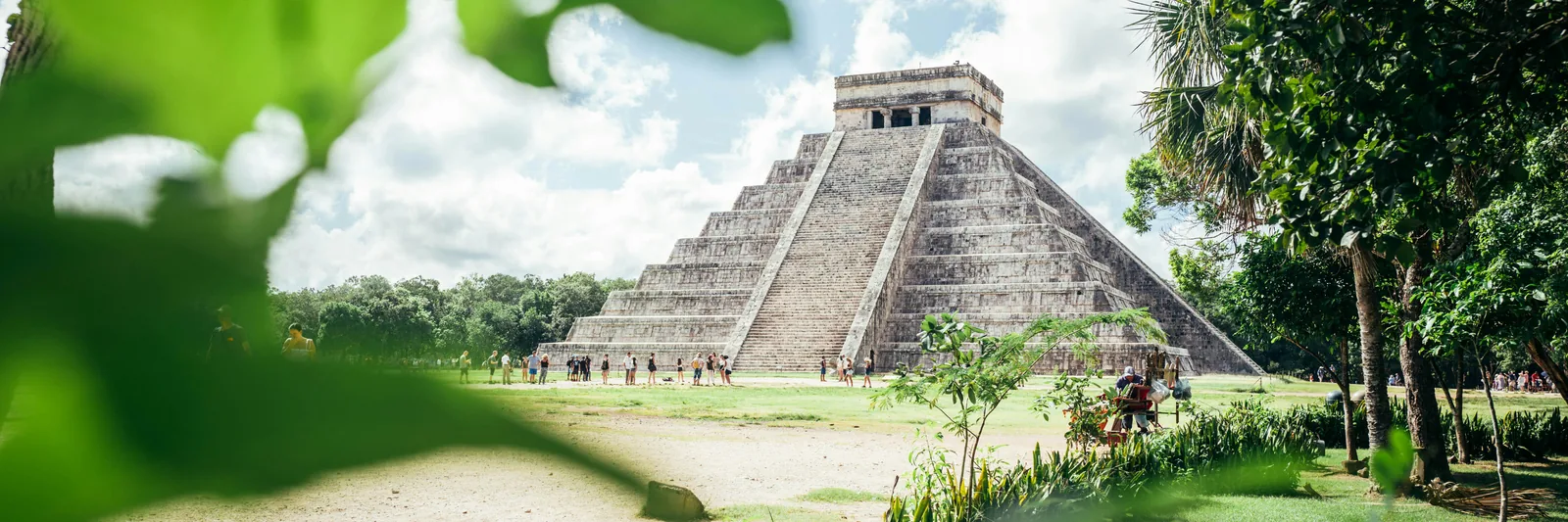 El Castillo pyramid at Chichen Itza above a green lawn in Yucatan, Mexico