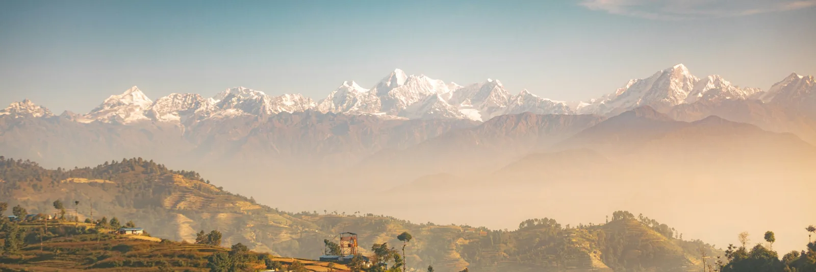 Snowy Himalayan peaks above foothill villages in Nepal
