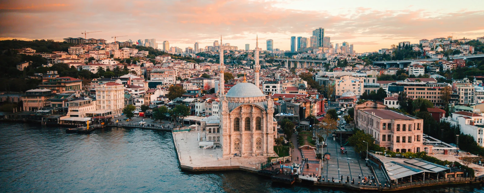 Ortaköy Mosque on Istanbul's waterfront beneath a pink sunset sky