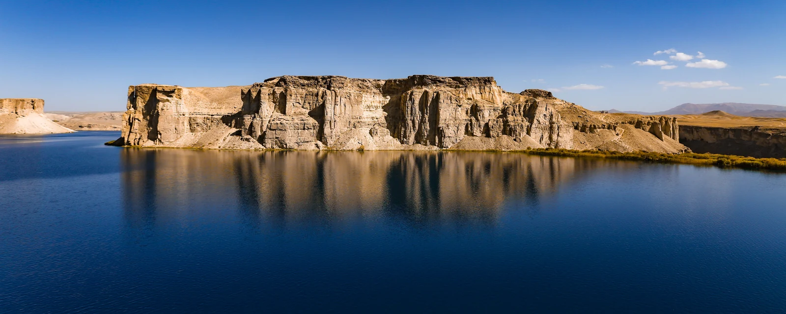 Golden cliffs reflected in the blue waters of Band-e Amir, Afghanistan