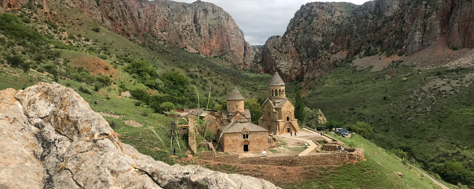 Noravank Monastery framed by green slopes and red cliffs in Armenia
