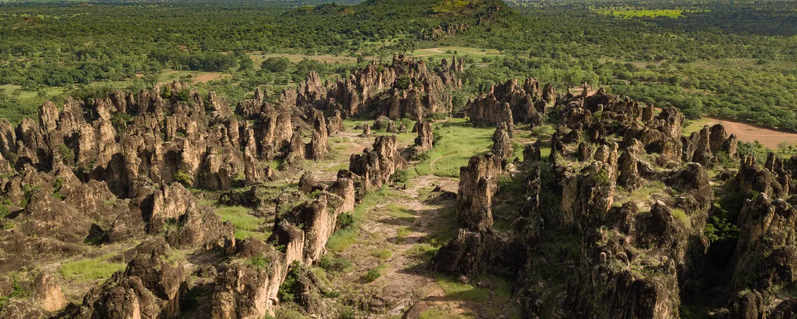 An aerial view of the sandstone Sindou Peaks surrounded by green countryside in Burkina Faso