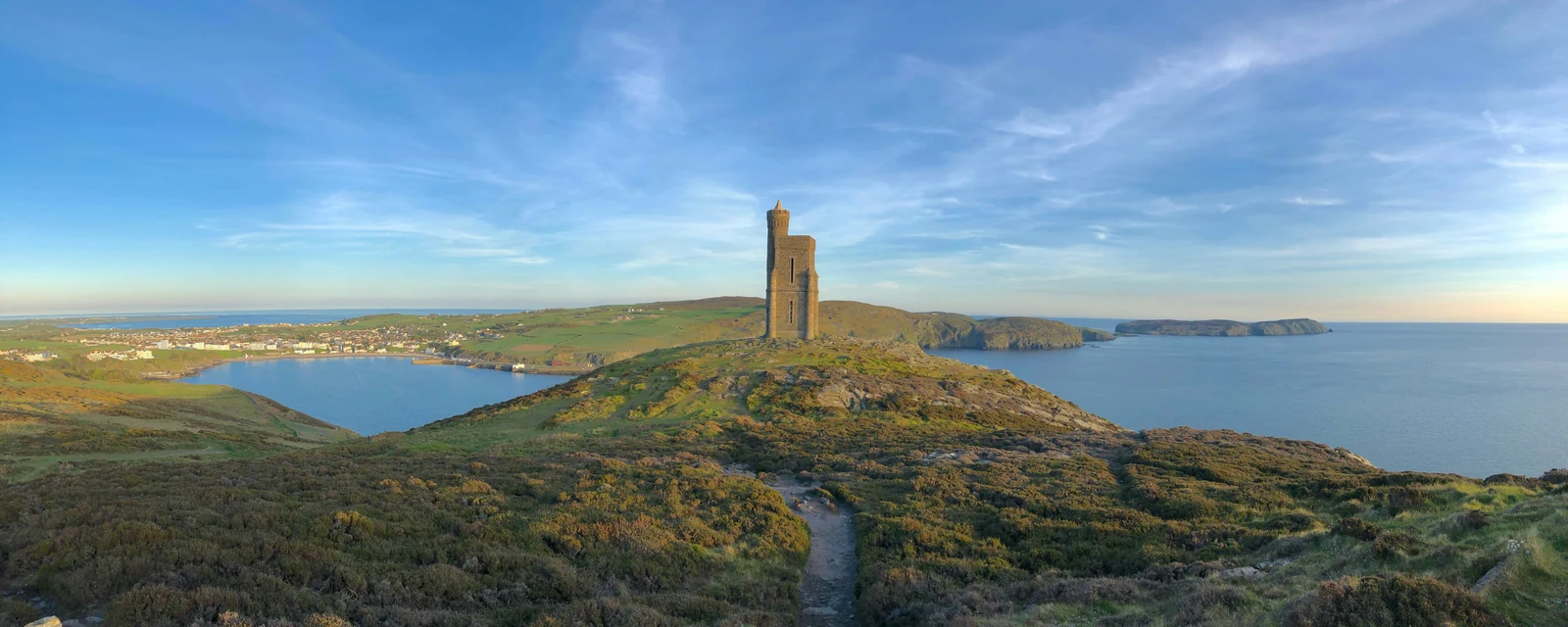Milnerโs Tower on Bradda Head overlooking blue bays and the summer coastline of the Isle of Man