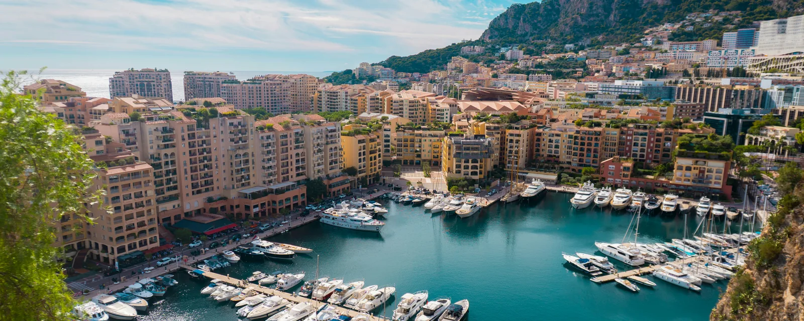 Turquoise harbour water and yachts framed by colorful waterfront buildings in Monaco