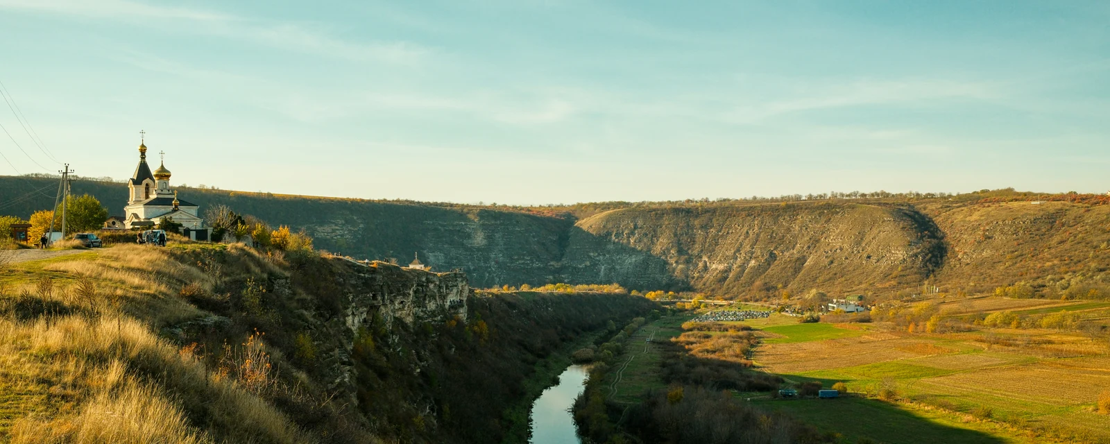 Warm evening light over the church, limestone valley and winding river at Old Orhei, Moldova