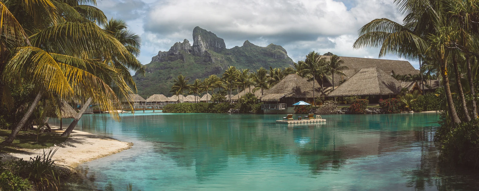 Mount Otemanu beyond palm-framed turquoise Bora Bora lagoon in French Polynesia