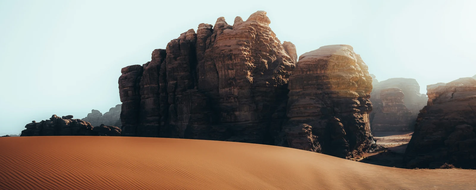 Sculptural sandstone plateau above rippled dunes in the Hisma Desert, Saudi Arabia