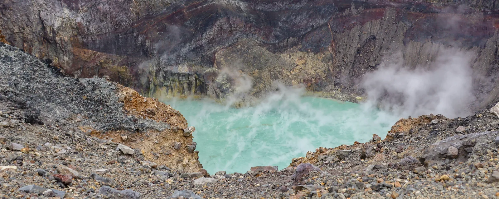 Turquoise water and drifting steam inside the layered crater of Santa Ana Volcano in El Salvador