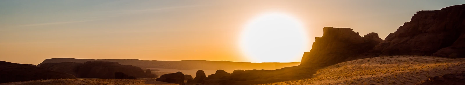 Warm sunlight over sandstone cliffs and desert in the Ennedi Plateau, Chad